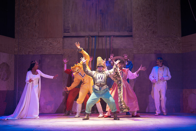 Production Image from A Midsummer Night's Dream, 2026. Actors dancing on stage in colourful costumes.