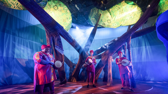 Show image - three women in african dress drumming in a play