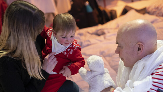 Actor interacts with a baby, with a puppet on his hand